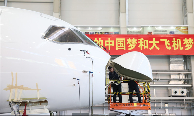 工作人員在中國商飛公司上海飛機制造有限公司總裝車間內對C919大型客機102架機進行調整工作。（新華社記者 丁汀 攝）