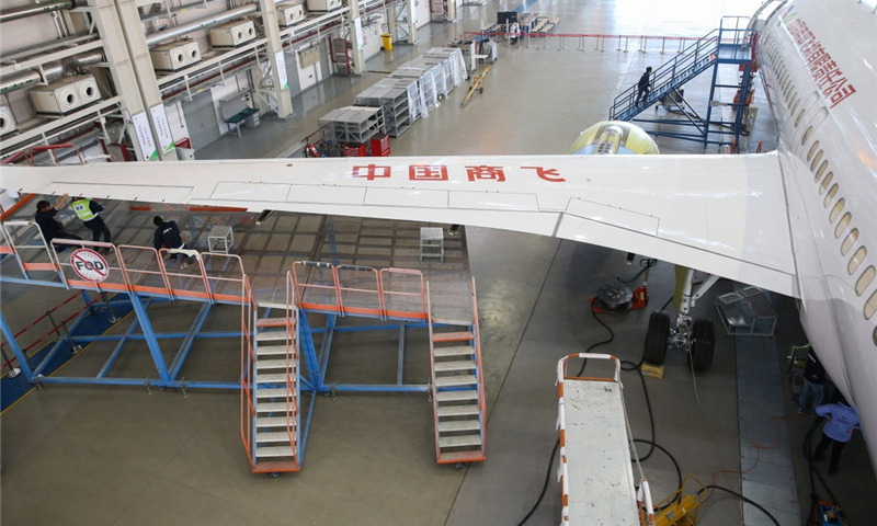 工作人員在中國商飛公司上海飛機制造有限公司總裝車間內對C919大型客機102架機進行調整工作。（新華社記者 丁汀 攝）