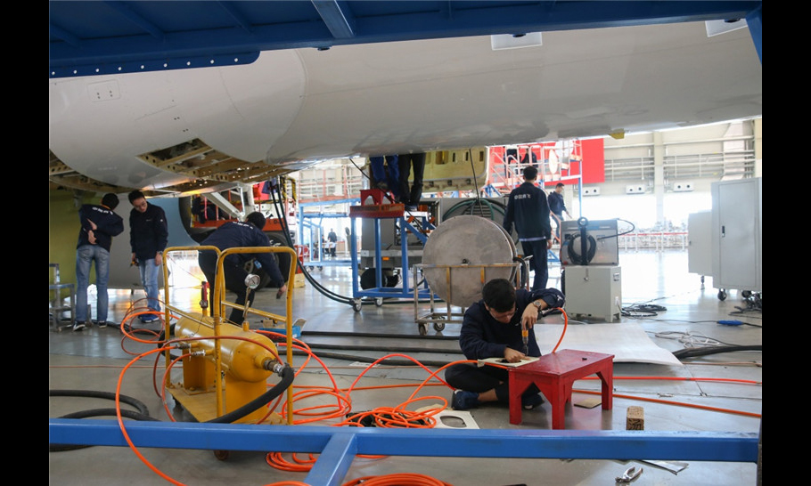 工作人員在中國商飛公司上海飛機制造有限公司總裝車間內對C919大型客機102架機進行調整工作。（新華社記者 丁汀 攝）