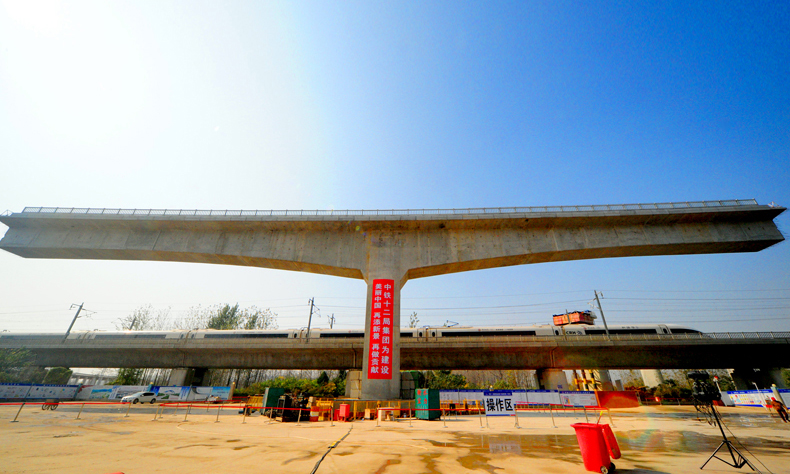 徐鹽鐵路京滬上行線跨京滬高鐵特大橋全長5839米，共141個橋墩，橋梁第89-91號墩處斜跨京滬高鐵既有線，采用平行懸灌及自平衡水平轉體法施工，轉體總重量約3800噸，轉動角度42度。圖為轉體前，梁體與京滬高鐵平行。