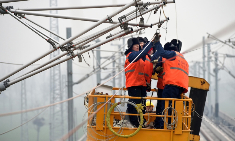 目前，以京廣、徐蘭（徐州至蘭州）高鐵為主體的鄭州“十”字形高鐵框架已經成型。鄭州至萬州、合肥、太原、濟南的四條放射線路也正在以“四路并進”的格局加速建設。通達八方的河南“米”字形快速鐵路有望“十三五”成網。圖為2015年12月7日，施工人員在徐蘭高鐵河南段一處施工現場安裝接觸網。（新華社記者 李安 攝）