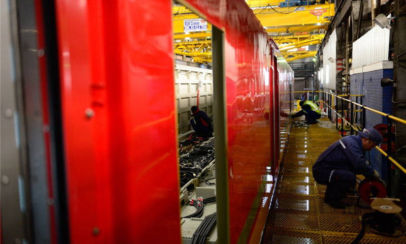 通過直接雇傭、間接推動南非本地企業用工等方式，為南非創造了數千個工作崗位。中國機車良好的運行表現和優質的售后服務，為南非錳礦、煤礦等貨物的出口提供強有力的運輸保障，獲得業主一致好評。圖為7月27日，在南非比勒陀利亞南非運輸集團工廠組裝車間，中南兩國技術人員在一臺待組裝的中國機車內外工作。（新華社記者 翟健嵐 攝）