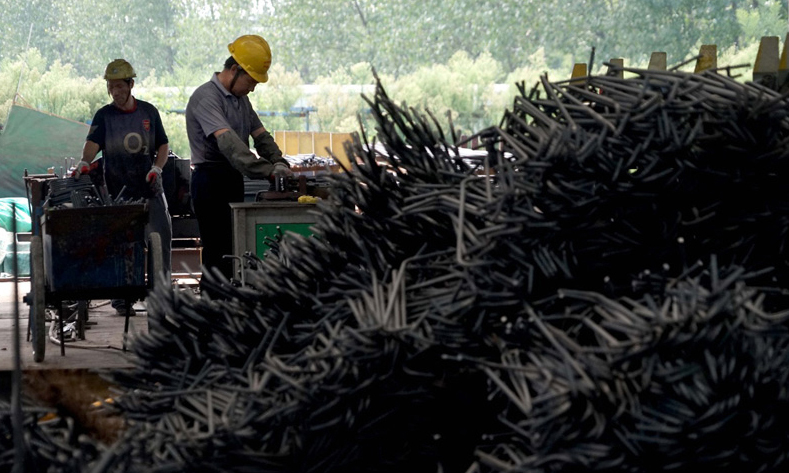 中鐵七局的工作人員在鄭萬高鐵一處制梁場內作業（新華社記者 李安 攝）。
