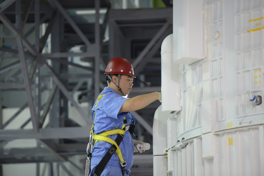 試驗隊員在長征七號火箭總裝廠房工作。（來源：中國航天科技集團公司）