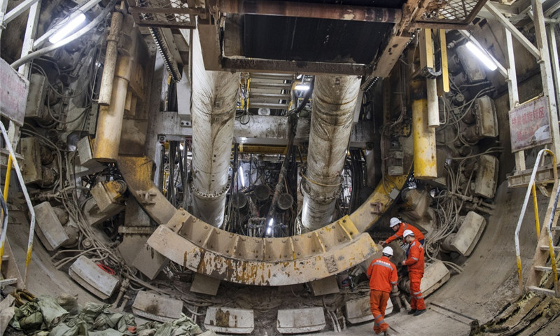 圖為2018年1月25日，參建人員在檢查即將出洞的大斷面馬蹄形盾構機。這臺馬蹄形盾構機能極大提高隧道空間利用率、降低施工成本和縮短施工工期。（新華社記者 陶明 攝）