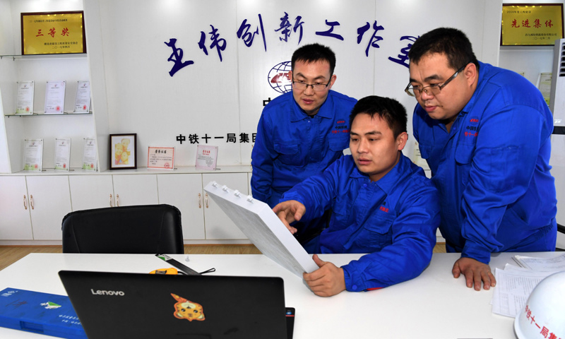 昌贛（南昌至贛州）客運專線，又名昌贛高鐵，總長約415.2公里，是規劃中京九客運專線的重要組成部分，設計行車速度為350公里/小時。在昌贛高鐵客運專線工程建設中，有一批年輕的技術骨干，他們將國內外的工作經驗和先進的管理理念運用到工作中，他們就是中鐵十一局橋梁公司王偉創新工作室。圖為2018年1月22日，王偉（中）和創新團隊成員在研究改進CRTSⅢ型先張法軌道板的預制工藝。（新華社記者 劉茜 攝）