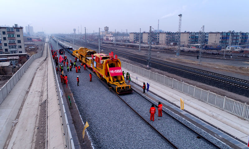 日前，內蒙古連接東北地區的首條高鐵——通遼至遼寧新民北高鐵開始全線鋪軌。為完成好寒冷氣候條件下的高鐵鋪軌任務，中鐵十四局通遼項目部施工人員提前做好技術、設備、人員等方面的充分準備。在零下20多攝氏度的條件下，他們采用2臺國內最先進、具有自主知識產權的CPG500型直鋪機進行鋪軌作業。圖為直輔機正在進行鋪軌施工。（攝影 尹輝）