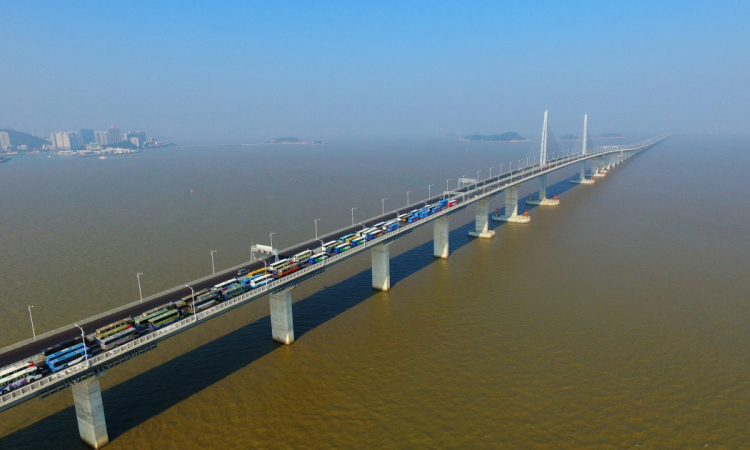 2017年12月31日，港珠澳大橋主體工程供電照明系統施工順利完成并全線亮燈。歷經6年籌備、8年建設的世界最長跨海大橋主體工程如期具備通車條件，符合工期計劃目標。圖為88輛大巴車和工程車集體開過港珠澳大橋，慶祝大橋主體工程具備通車條件。（新華社記者 梁旭 攝）