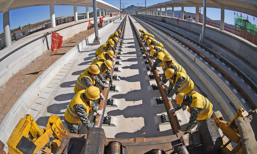 京沈高鐵起自北京星火站，經河北省承德市、遼寧省朝陽市、阜新市接入沈陽站，線路全長698公里，設計時速350公里。圖為2017年9月28日，中鐵十九局工程人員在京沈高鐵凌源南站進行鋪軌作業。（新華社記者 楊青 攝）