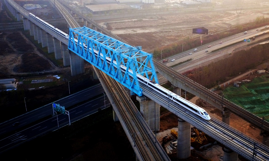 2017年12月6日，西安至成都高速鐵路全線開通運營，兩地的最短旅行時間壓縮至4小時7分。圖為西成高鐵由西安北站駛出的列車經過西成高鐵跨西寶高鐵特大橋。 （新華社記者 劉瀟 攝）