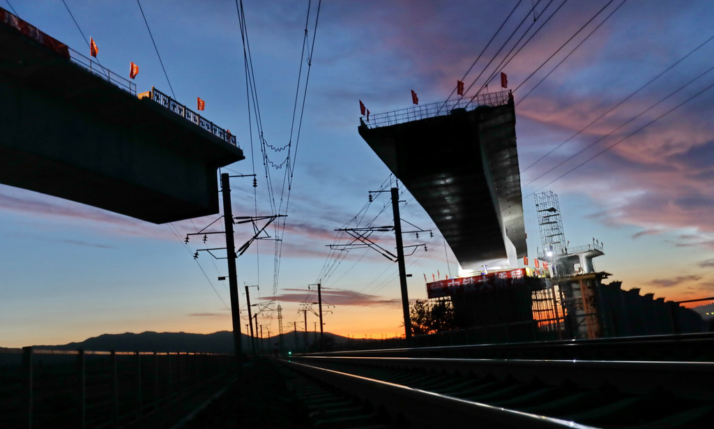 2016年4月，京張高鐵正式開工建設，計劃2019年年底通車。京張高鐵建成后將是我國第一條在高寒、大風地區達到設計時速350公里的有砟軌道高速鐵路。圖為河北省懷來縣境內的新建京張高鐵跨大秦鐵路線土木特大橋連續梁在轉體中。（新華社記者 楊世堯 攝）