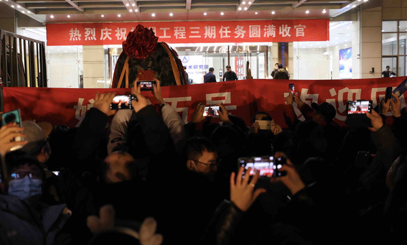 12月17日晚，在完成必要的地面處理工作后，嫦娥五號返回器被空運至北京并正式回到“出生地”——中國航天科技集團五院。按計劃，回收后的嫦娥五號返回器將取出樣品容器及搭載物。國家航天局將擇機舉行交接儀式，正式向地面應用系統移交月球樣品，我國首次地外天體樣品儲存、分析和研究相關工作也將隨之啟動。圖為當晚，在北京中國航天科技集團五院，人們在歡迎嫦娥五號返回器回到出生地。（新華社記者 金立旺 攝）