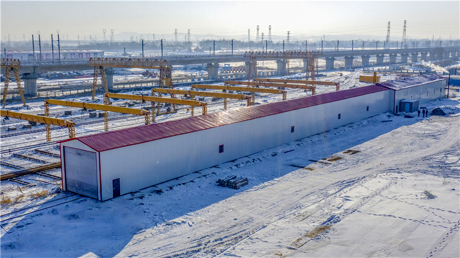 原本10個月的工期壓縮成了8個月，為確保鋪軌節點如期實現，項目部用空間換時間，通過增加工作面，見縫插針地分段鋪設，同時增加人員和設備投入，先后調撥鋪軌機3臺、移動閃光焊機3臺、機車15臺、路用平板130輛、大型養路機械8臺、道砟車60輛、吊車12臺，施工旺季1000人以上。通過優化資源配置，項目部創造了佳木斯至雙鴨山段大坡道左線日鋪軌7公里、提前23天鋪通的施工紀錄，為牡佳客專按時開通打下堅實的基礎。圖為機車恒溫庫。