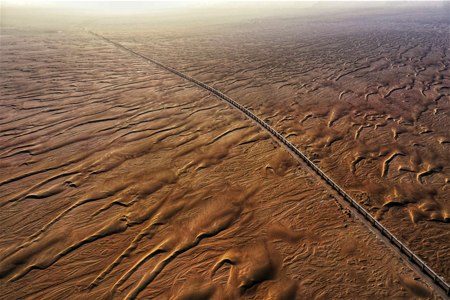 據中鐵十一局三公司和若鐵路項目經理蘇興旺介紹，若克雅特大橋于2020年11月底完成全部架梁任務；尼雅河特大橋計劃在2021年3月底完成全部架梁任務。圖為穿越沙漠的尼雅河特大橋。（汪建鴻 攝）