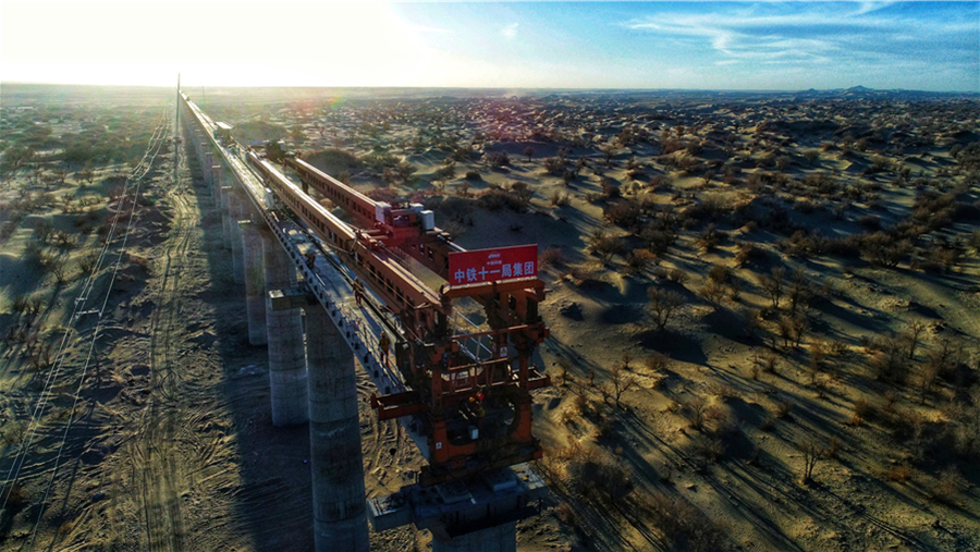 和若鐵路位于新疆和田地區和巴音郭楞蒙古自治州境內，線路全長825.476公里，為客貨共用單線鐵路，設計時速120公里，計劃2022年建成通車。圖為若克雅特大橋架梁現場。（汪建鴻 攝）