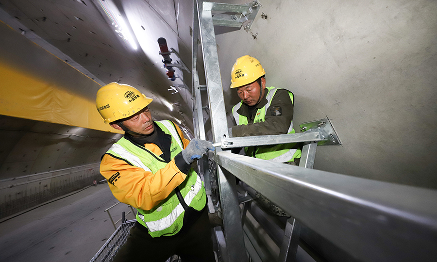 穿黃隧道盾構段龍骨骨架試拼的完成，解決了機電安裝中的消防噴淋與側墻龍骨骨架相互交叉的技術問題，避免了隧道內電焊施工過程中產生的焊煙等污染，同時，利用叉車替代人工加快了施工效率，為隧道后期順利通車奠定了堅實的基礎。圖為工人在隧道內進行龍骨骨架安裝。（范成濤 攝）