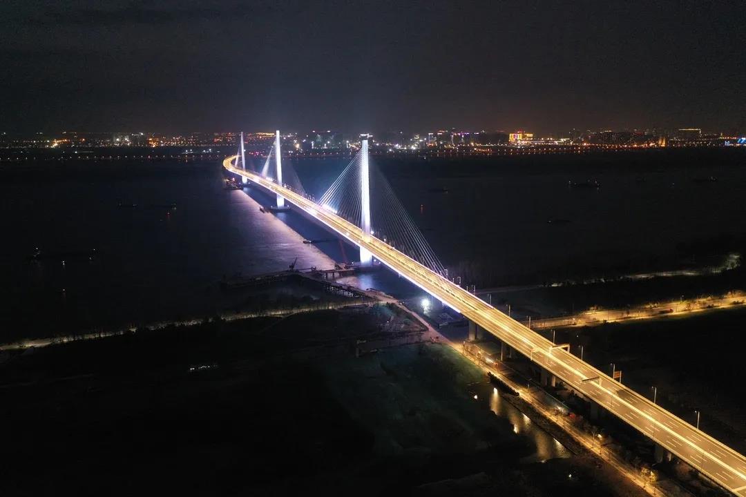 南京長江五橋連接江北新區、江心洲、河西新城三大區域，具有良好的景觀效應和價值，大橋設置了色彩多樣、變化多姿的景觀燈，除了常亮路燈外，紅、黃、藍、綠、白五種顏色景觀呼吸燈間次照亮主塔與斜拉索。呼吸燈是指燈光在微電腦的控制之下完成由亮到暗的逐漸變化，感覺好像是人在呼吸。圖為南京長江五橋夜景。