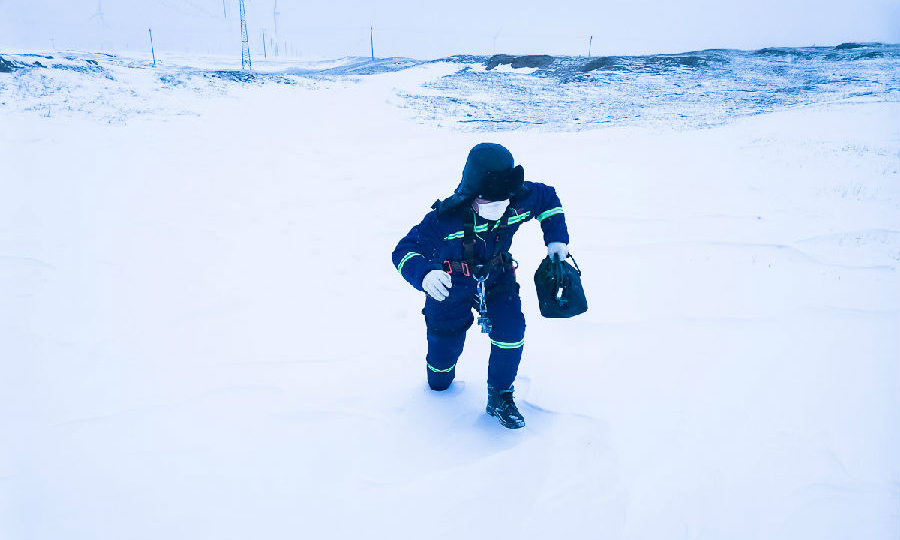 國華投資通遼國泰風電場檢修員工攜工器具徒步救援外出檢修受困車輛。（馬海明 攝）
