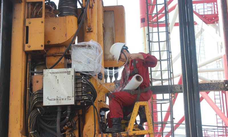 為應對臺風，近日中國海油所屬中海油服密切關注臺風路徑信息和現場作業進度，協調防臺資源。鉆井平臺提前周密部署，按照防臺預案開展現場設備工具固定、應急設備設施檢查、艙室水密檢查、室外電氣設備防護等，將臺風帶來的影響降到最低，確保生產作業順利開展，為沖刺年度生產經營目標保駕護航。圖為“海洋石油931”鉆井平臺電氣師在撤臺前為頂驅電纜箱及電纜格蘭包裹防護膜，落實防風雨措施，保障電氣線路安全。