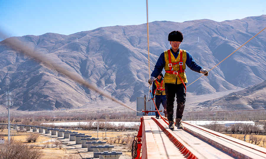 在1.1米寬幾十米高的空中作業，可以說是鋪架隊最危險的工種之一了，在拉林尖刀班里1號車指揮每天至少在架橋機大臂上往返3至4次，是架梁工作的排頭兵。（丁慶濱 攝）