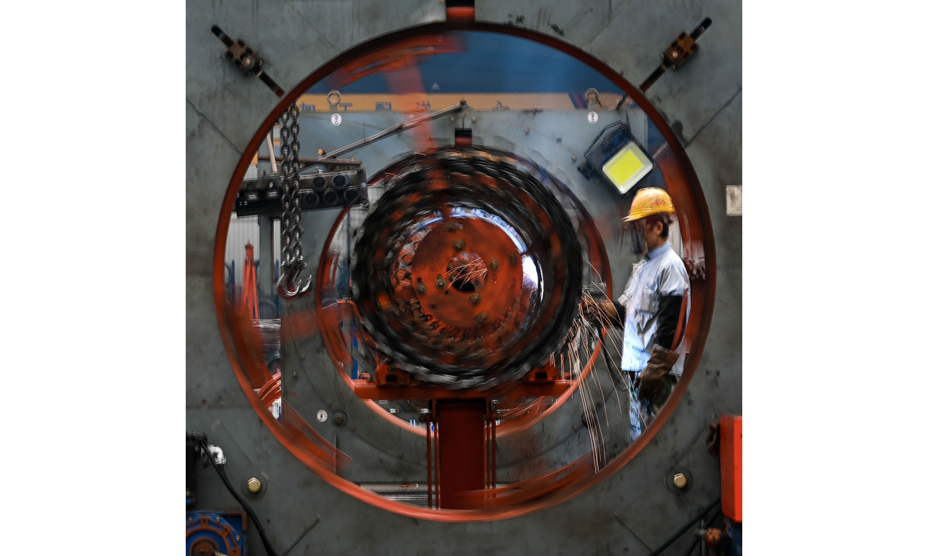 為高效服務粵港澳大灣區基礎設施建設，中國鐵建華南建設有限公司在廣州番禺區和南沙區設立3家裝配式工廠，形成華南地區目前規模最大的鋼材和混凝土制品加工配送中心，保障了廣州市軌道交通18號線、22號線和10號線的鋼材、混凝土軌枕供應。這些裝配式工廠對生產及配送采用信息化管理，能夠實時掌握生產及配送動態，準確及時地將產品交送到建設一線。圖為9月20日，工人在中國鐵建華南建設有限公司番禺鋼材加工中心的智能鋼筋籠滾焊機生產線上進行焊接作業。（新華社記者 劉大偉 攝）