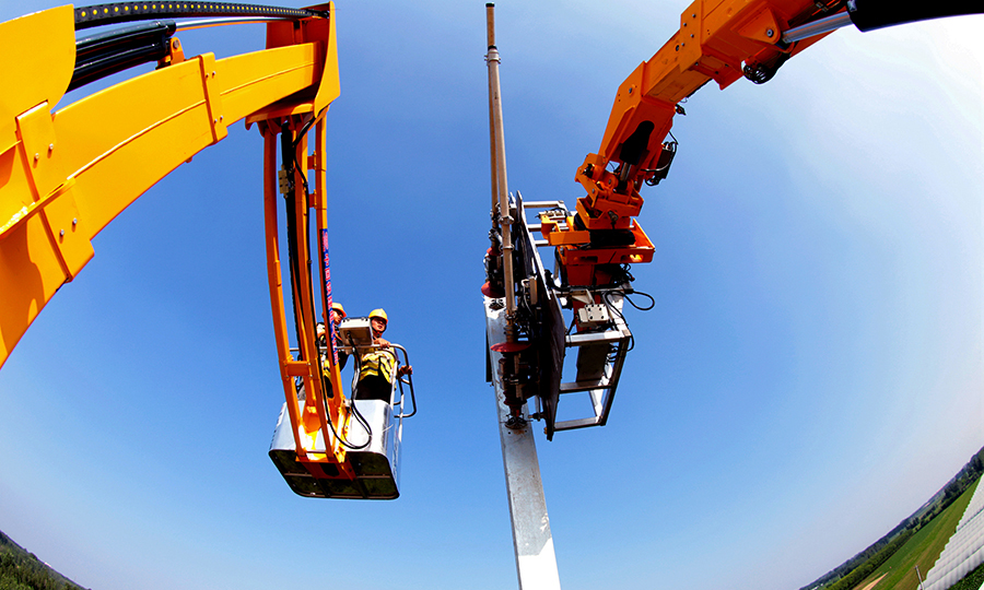 此次投入使用的接觸網三型智能裝備包括：支柱組立智能裝備、腕臂安裝智能裝備和參數檢測及吊弦標定智能裝備。圖為中國鐵建電氣化局京雄城際鐵路（河北段）技術人員正在作業平臺上，運用智能操作系統指揮智能化運送平臺推送腕臂。（鄭傳海 攝）