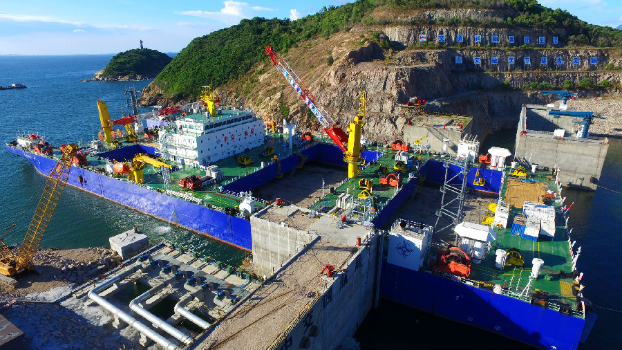 深中通道海底隧道部分是世界首例雙向八車道鋼殼海底沉管隧道，E2管節為首個標準管節，長165米，寬46米，高10.6米，重約7.7萬噸。比不久前完成安裝的E1管節比41.5米、重量超出2萬噸。標準管節E2在施工工藝、安裝條件等方面面臨多個“第一次”：為保證作業安全，中交集團所屬中交一航局科研團隊對E2管節與一體船的連接進行重新核算。圖為施工現場。