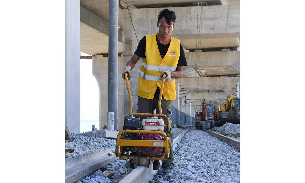 圖為7月20日，中鐵二十四局施工人員在平潭海峽公鐵大橋進行最后一根長軌的螺絲緊固工作。（新華社記者 林善傳 攝）