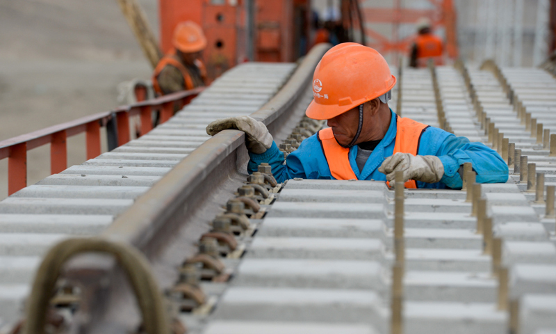 圖為7月18日，中鐵一局的施工人員在檢查軌排。（新華社記者 丁磊 攝）