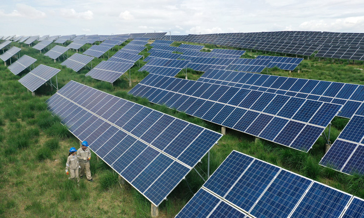 國家電網青海省電力公司數據顯示，截至6月30日，青海電網累計外送電量106.9億千瓦時，同比增長32%，突破100億千瓦時。其中，清潔能源外送電量102.3億千瓦時，同比增長41.8%。圖為7月8日，在青海省海南藏族自治州共和縣，大唐青海公司新能源分公司兩名工作人員在光伏電站內巡檢。（新華社記者 張宏祥 攝）