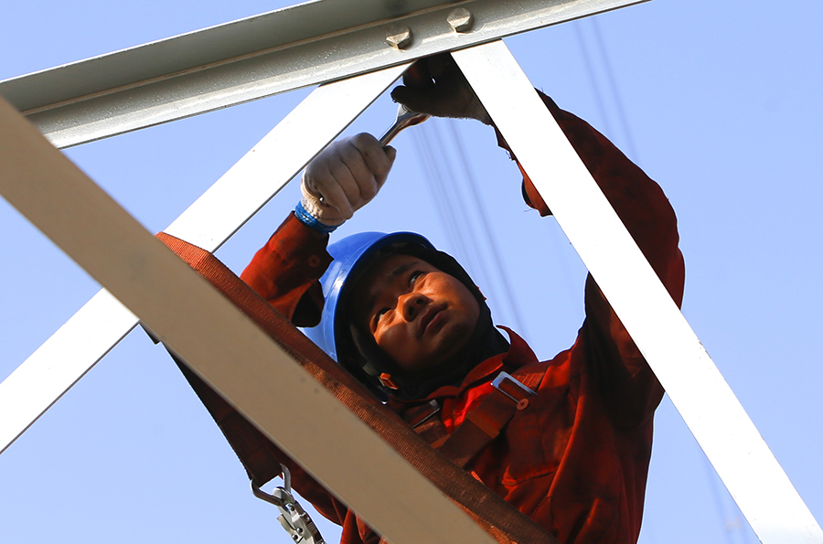 針對各項不利因素，面對只能成功不能失敗的任務，項目部根據實際情況，對每條線路制定獨有遷改方案。圖為工人正在組立電力鐵塔。（范成濤 攝）