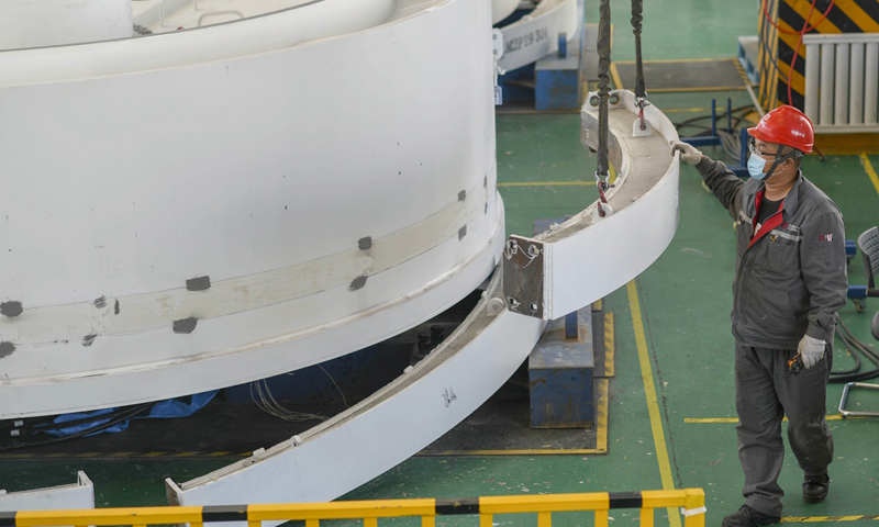 位于新疆哈密市的哈密中車新能源電機有限公司3月15日起全面復工復產。截至目前，已先后完成新疆、青海、甘肅等地的發貨，第一季度產能同比2019年增長5%。圖為4月25日，在哈密中車新能源電機有限公司生產廠房，工人安裝直驅永磁風力發電機。（新華社記者 趙戈 攝）