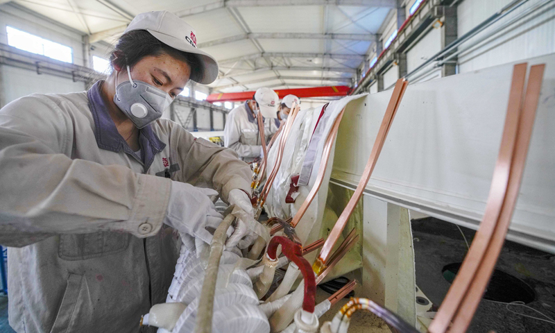 4月25日，在哈密中車新能源電機有限公司生產廠房，工人在直驅永磁風力發電機生產線上忙碌。（新華社記者 趙戈 攝）