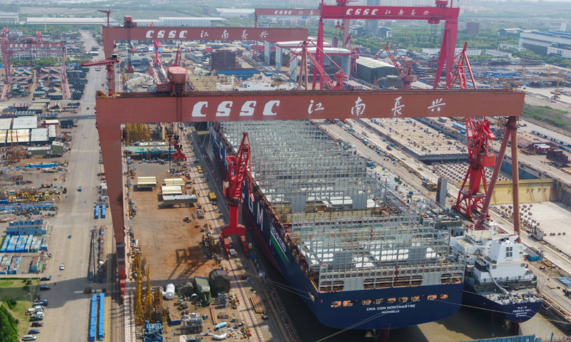 江南造船3號船塢長580米，寬120米，是目前國內在用的最大船塢。為了充分提升船塢利用效率，江南造船采取“雙線并造”模式，即一批次液化氣船和一批次超大型集裝箱船同時建造。圖為江南造船3號船塢內的84000立方米超大型液化氣船和23000箱集裝箱船。（新華社記者 丁汀 攝）