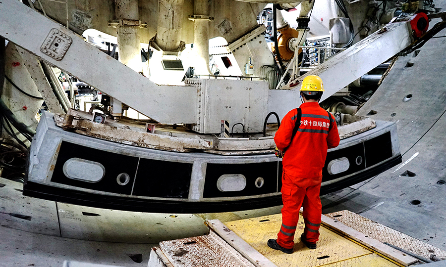 為確保順利穿越，穿越前對刀盤刀具進行抽檢并更換，推進過程中嚴格監測土倉壁溫度并加強刀盤中心沖刷力度，確保刀具完好，刀盤無泥餅堆積，一次性穿越大堤。圖為管片拼裝。