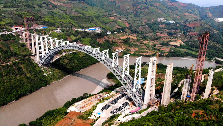 近日，隨著一塊重達120噸的鋼箱梁節段穩穩落在大橋拱上立柱上，標志著世界跨度最大的鐵路拱橋——大瑞鐵路怒江特大橋進入梁部施工階段。圖為航拍的大瑞鐵路怒江特大橋。