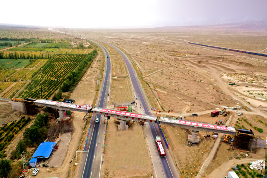 8月31日，由中國鐵建所屬中鐵十四局三公司承建的“絲綢之路經濟帶核心區”建設的重點工程，新疆首個三墩轉體橋——中泰鐵專跨吐（魯番）和（田）高速公路跨轉體橋，逆時針旋轉70度成功轉體。這也是南疆地區首個轉體橋，采用“鋼殼合龍”的方式，對吐和高速的影響幾乎為零。項目建成后，將助力上庫石油石化產業園初步形成400萬噸/年運載能力。圖為轉體完成的橋梁。