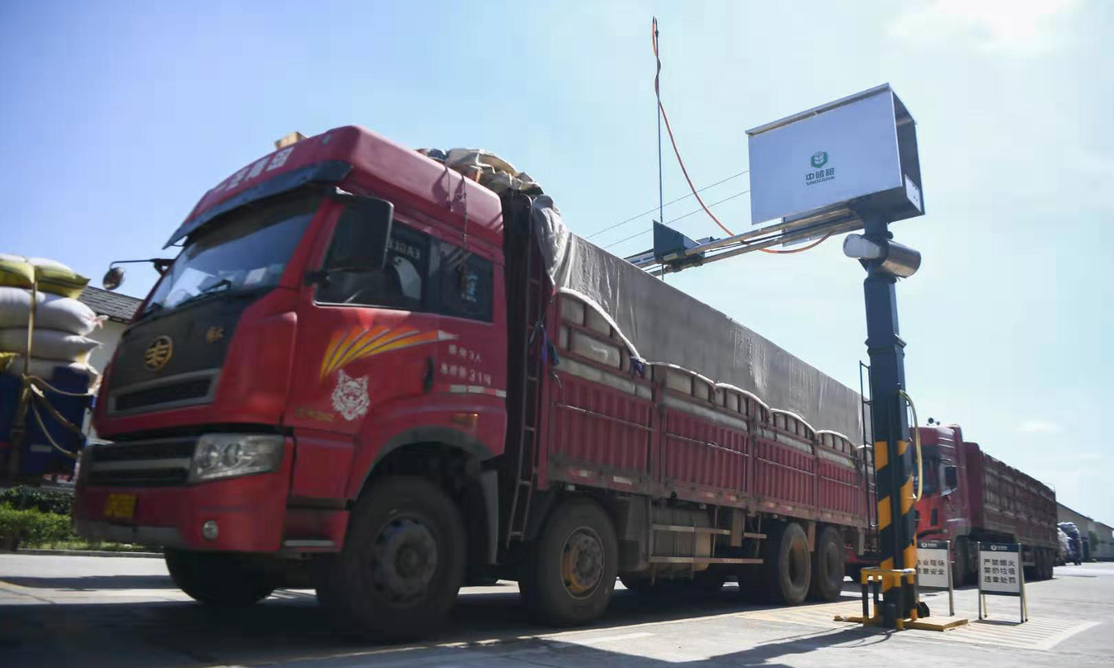 正值夏糧收購時節，記者來到位于湖南寧鄉的中央儲備糧寧鄉直屬庫進行探訪。為保證入庫糧食的質量，中儲糧寧鄉直屬庫應用機械對糧食進行扦樣檢測、確定糧食等級，只有達到國家標準三等及以上的才允許入庫。智能控溫、氮氣殺蟲、超清監控等技術手段在倉庫中應用，確保了糧食在儲存過程中不會輕易發生蟲害和變質。隨著智能化、信息化水平不斷提高，科技在糧食存儲中的作用日益體現。圖為7月30日，裝滿糧食的卡車在中儲糧寧鄉直屬庫排隊等候扦樣。（新華社記者 薛宇舸 攝）