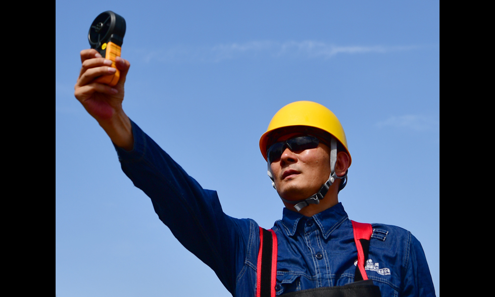 圖為7月30日，在河南省新安縣正村鎮上坡村，尤寧在帶電作業現場測量風速。（新華社記者 馮大鵬 攝）