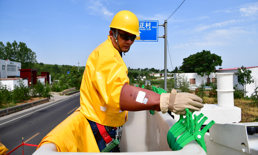 停電作業時，電是“死老虎”；但帶電作業時，醒著的“電老虎”隨時可能發威。“作業時最怕操作失誤導致短路，電流可能瞬間擊穿護具，帶來燒傷等電弧傷害。”尤寧說，“帶電作業需要慎之又慎，才能將危險降到最低，確保萬家光明。”圖為7月30日，在河南省新安縣正村鎮上坡村，尤寧進行帶電作業。（新華社記者 馮大鵬 攝）