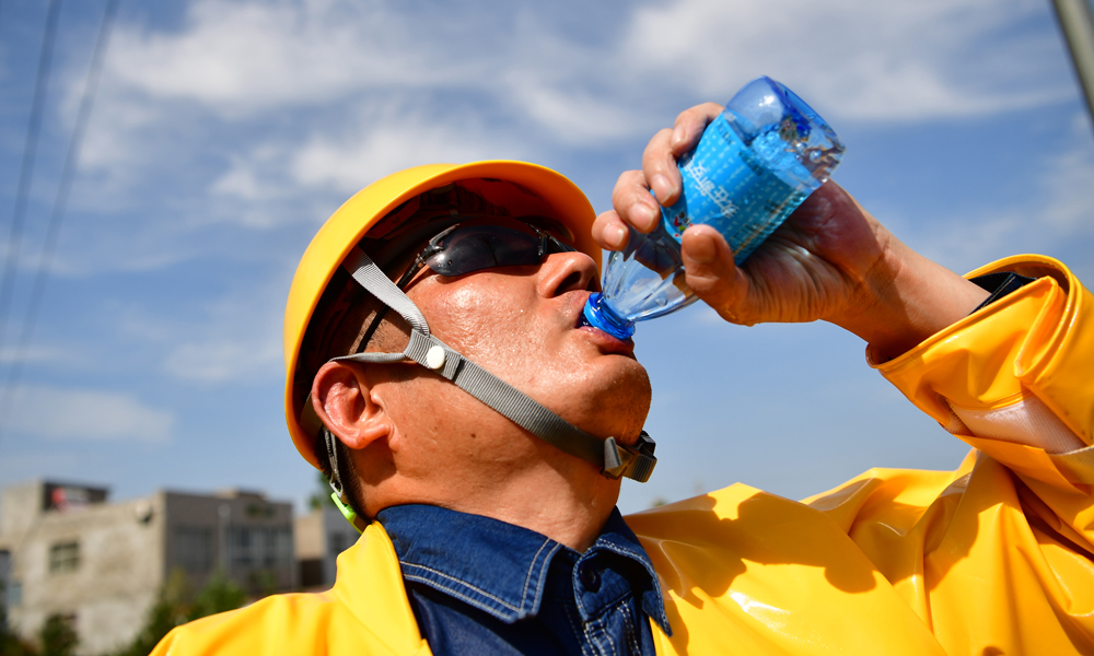 圖為7月30日，在河南省新安縣正村鎮上坡村，尤寧結束帶電作業后緊急補水。（新華社記者 馮大鵬 攝）