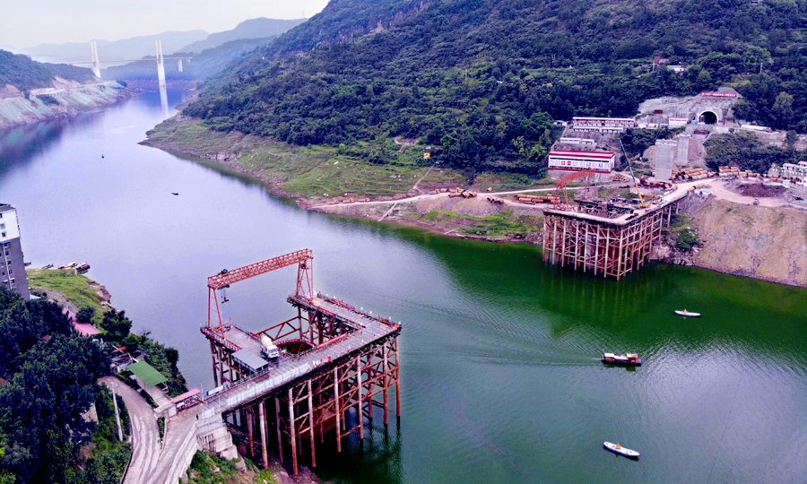 彭溪河多線特大橋位于重慶市云陽縣黃石鎮，由中國鐵建所屬中鐵十一局集團承建，大橋跨越長江一級支流彭溪河，橋長741.6米，共14跨。其10號和11號兩個主墩處于河段最高水深約60米的斜巖環境里。主墩橫穿三峽三期蓄水庫區，有三級通航要求，通航水位落差達30多米。圖為無人機拍攝的彭溪河多線特大橋施工現場。（劉興敏 攝）