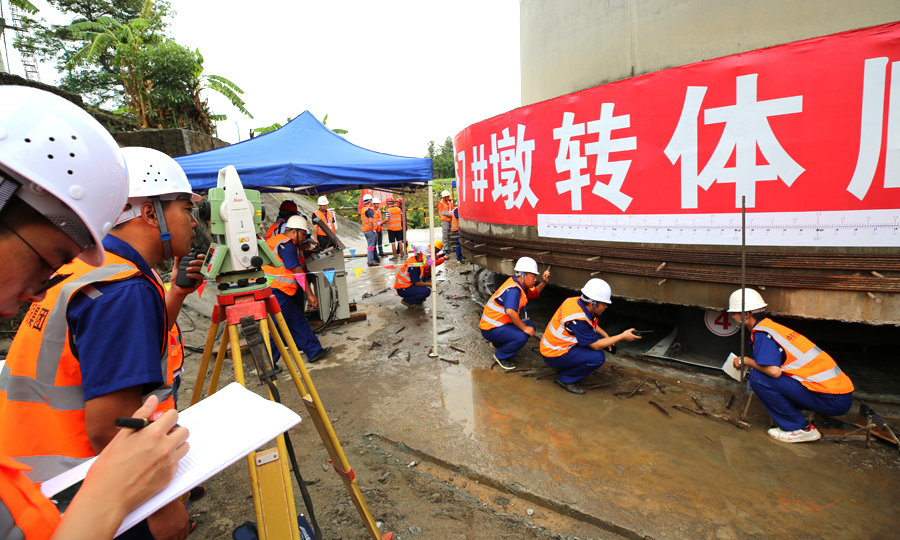 橋梁轉體的關鍵部件是直徑3.6米的圓盤形球鉸裝置。它下部與大橋的承臺緊密連接，上部是13層樓高、重量與1500頭大象相當的橋梁。在轉體時，分列橋梁兩側的兩臺千斤頂，牽引鑲嵌在墩身承臺里的26根成人大拇指粗細的鋼絞線，大橋即可以每分鐘轉動近1度的速率緩緩轉動，直至轉體完成。圖為現場技術、安全人員全程認真盯控，確保大橋安全跨越老成昆鐵路。