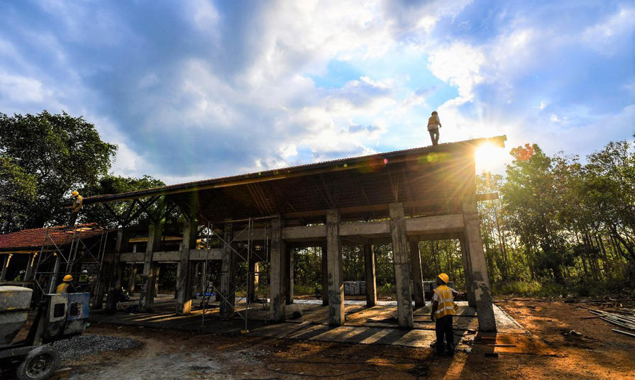 當地工人正在夕陽下的公益課堂項目工地施工。