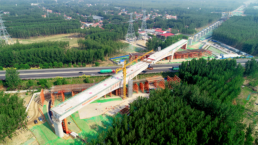 據悉，固安特大橋跨廊涿高速連續梁主跨長128米，分節段在廊涿高速公路兩側支架現澆完成后，采用墩頂平轉法，雙向并行勻速逆時針轉體39.5度完成梁體合龍，梁體轉體重量約為9000噸，轉體梁在下滑道上走行距離為52.7米。圖為轉體完成。