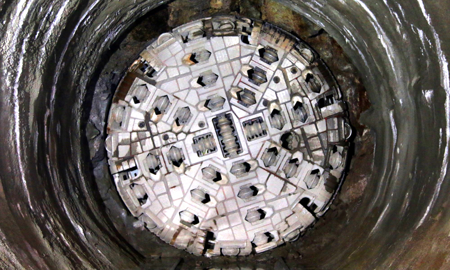 由于巖層太硬，在掘進中TBM換刀非常頻繁，遇到巖層堅硬或者埋深較深區域，每天需要更換五六把刀，一周就需要將整個刀盤全部更換一次，整個掘進過程更換刀具2000余把，平均每2米1把。圖為盾構機露出“大鋼牙”。