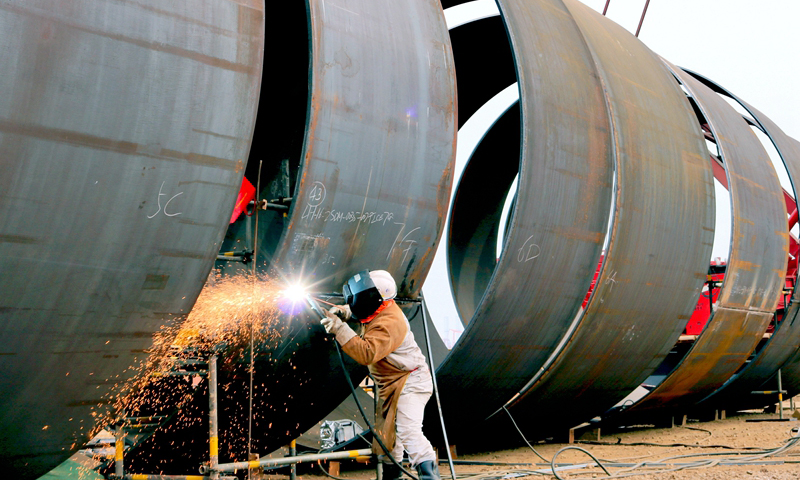 流花16-2 FPSO（浮式生產儲卸油裝置）項目是中國海油所屬海油工程承攬的第一個國內大型FPSO建造項目，單點系統中吸力錨鋼樁如巨龍一般，直徑為5500毫米、最大壁厚50毫米，單節管最重達16噸。海油工程通過優化施工流程、強化施工質量過程管控等具體措施，保證大型鋼樁接長工作的順利開展。圖為3月19日，該項目施工作業現場，一名焊接人員正全神貫注地進行單點吸力錨鋼樁縱縫焊道的清根作業。（戴世超 楊超 攝）