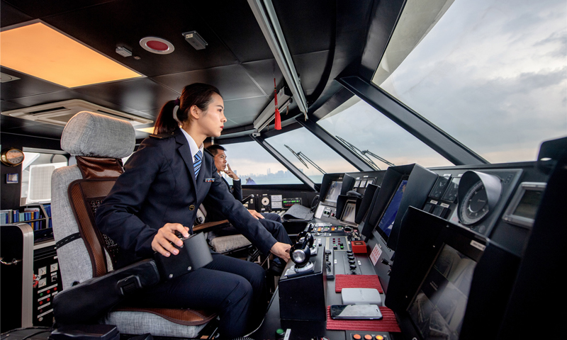 身為公司唯一女駕駛員，何倩倩和其他船員一樣，每月固定幾天留在船上值守夜泊班，對船上的安全設施進行檢查保養。圖為3月5日，何倩倩在駕駛高速客船。（唐蜀全 攝）