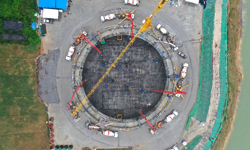 近日，“世界第一拱”——廣西貴港市平南三橋施工取得節點性進展，廣西北部灣投資集團所屬廣西路橋公司承擔該橋建設任務。經過76小時連續奮戰，北岸拱座基礎順利完成14060方混凝土澆筑。圖為施工現場。（黃煥亮 攝）