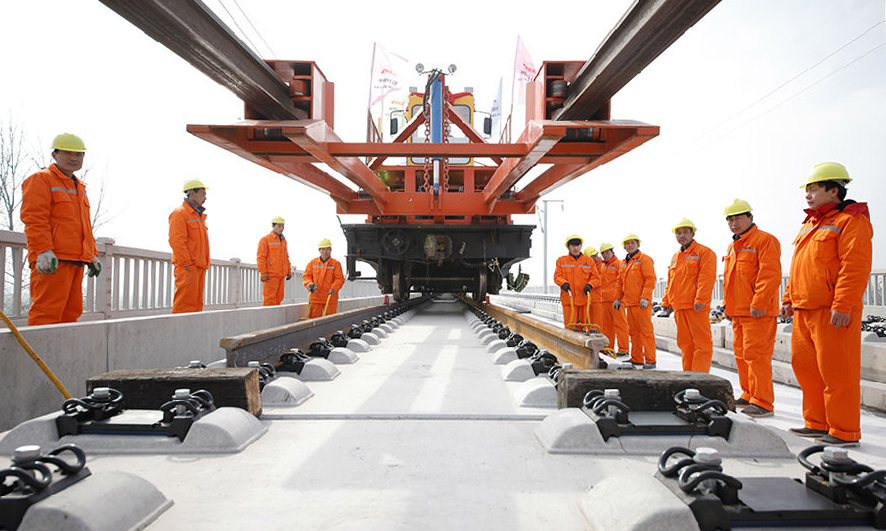 作為商合杭高鐵全線最大鋪軌基地，中鐵十八局五公司管區內古城集鋪軌基地可同時存儲960根500米鋼軌，滿足240公里鋪軌需求。軌道鋪設由古城東站分別向河南商丘與安徽阜陽兩個方向進行，日鋪軌可達6公里。作為我國“八縱八橫”路網規劃和京九高鐵的重要組成部分，商合杭全線預計2020年建成運營，將與長三角城際軌道交通圈形成互聯互通。（徐輝 攝）